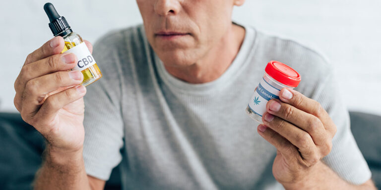 Cropped-view-of-man-in-t-shirt-holding-medical-cannabis-and-cannabis-oil.jpg