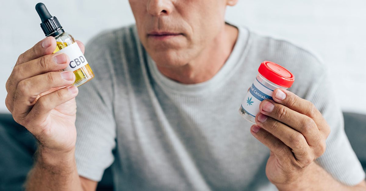 Cropped-view-of-man-in-t-shirt-holding-medical-cannabis-and-cannabis-oil.jpg